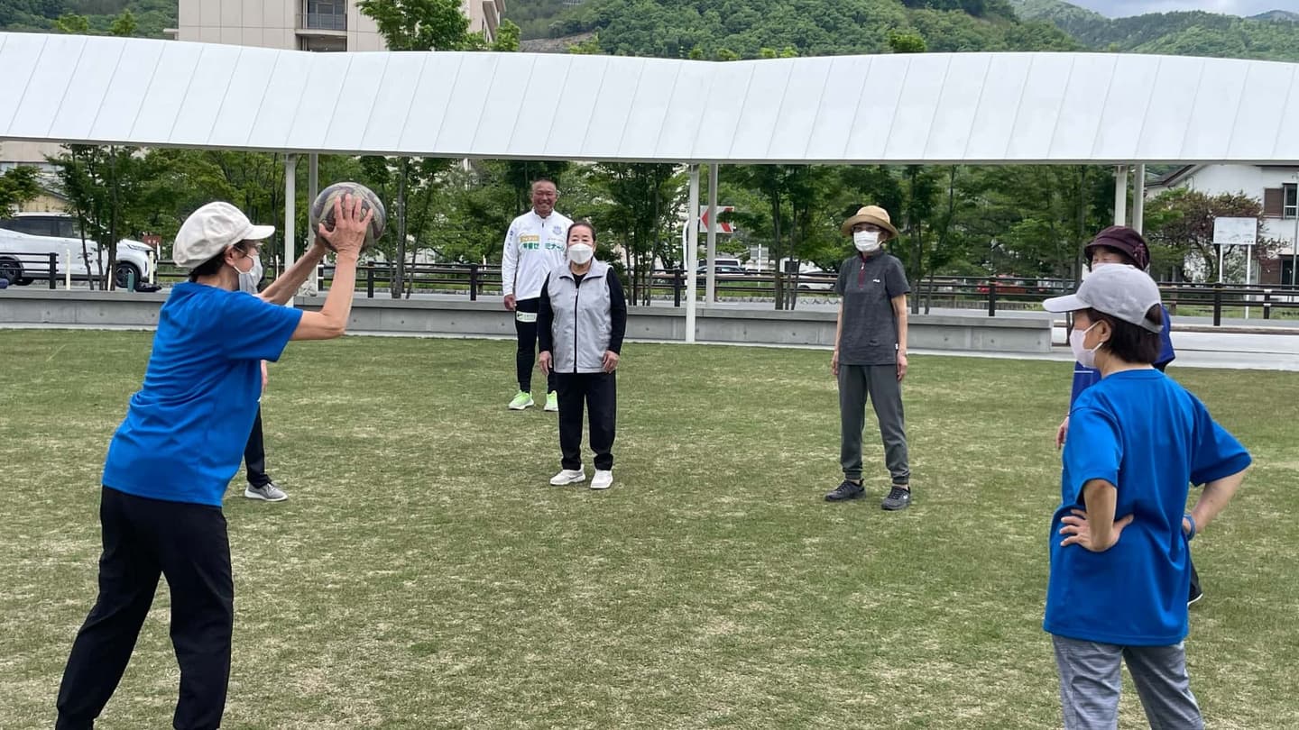 屋外でボールを使った運動を楽しむシニア世代